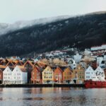 houses near body of water and mountain during daytime