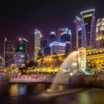 Dazzling view of the Singapore cityscape with Merlion and illuminated skyscrapers at night.