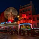 Paris Nightlife, a large ferris wheel in front of a building